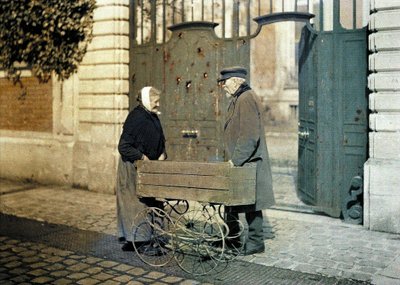 Zwei Senioren aus Reims, eine alte Frau und Herr Reiser, stehen vor einem Tor mit vielen Einschusslöchern, Reims, Marne, Frankreich, 1917 von Fernand Cuville